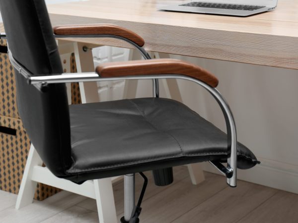 Stylish workplace interior with office chair and wooden table, closeup